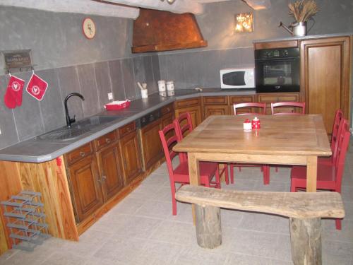 una cucina con tavolo in legno, tavolo e sedie di Gite De Charme Auvergne Cab'âne a Brousse