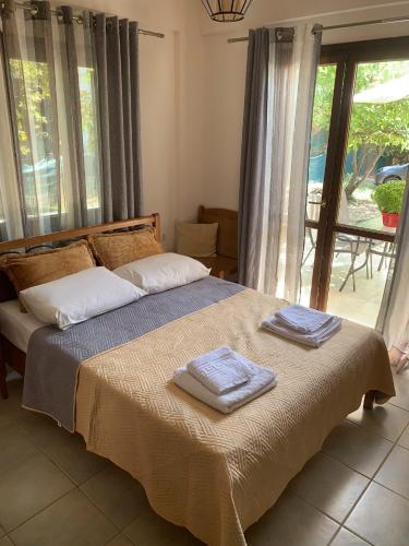 a bedroom with a bed with two towels on it at Olympia's Seaside Lefokastro in Lefokastro