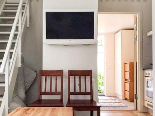 ein Wohnzimmer mit 2 Stühlen und einem TV an der Wand in der Unterkunft 3 person holiday home in Sölvesborg-By Traum in Sölvesborg