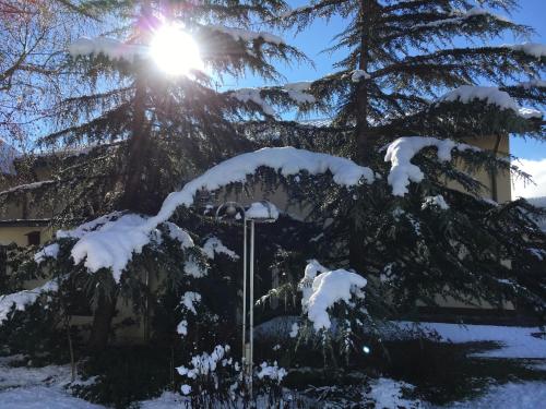 a street light covered in snow next to a tree at Pension & Apartments Ertl in Seeboden