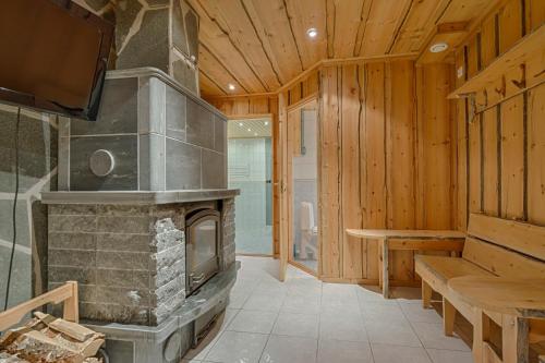 a living room with a stone fireplace and a tv at VIP Rakka Villas 7 & 8 in Levi