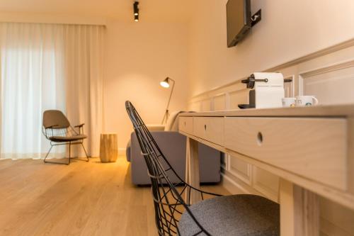 een woonkamer met een tafel en stoelen en een televisie bij De Sjeiven Dorpel in Maaseik