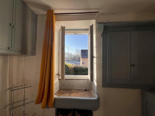 a window in a kitchen with a view of a building at La Petite Ecluse in Tanlay