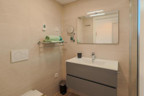 a bathroom with a sink and a mirror at Luxury Penthouse - Santa Rosalia Lake and Life Resort in Torre-Pacheco