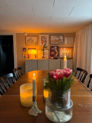 a dining room table with candles and flowers on it at Stuga nära Ullared Mitt i Åkulla bokskogar in Rolfstorp