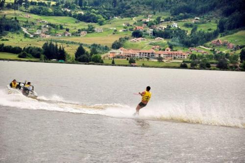 two people are water skiing on a lake at Apartamento Paipa Boyacá "Las Quintas" in Paipa