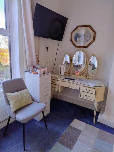 a dressing room with a desk with mirrors and a chair at Rooms in historic Bishop Auckland in Bishop Auckland