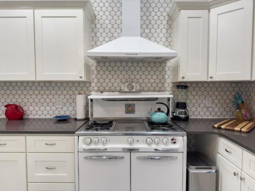 a kitchen with white cabinets and a stove top oven at Elk River Hotel & Cafe in Sutton