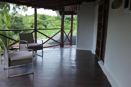 a room with two chairs and a table and a balcony at El Arca de Pachue in Punta Chame
