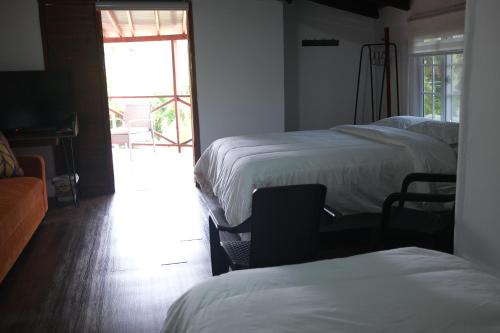 a room with four beds and a television and a window at El Arca de Pachue in Punta Chame