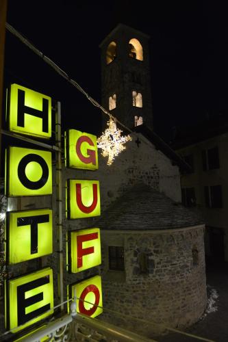 a building with a clock tower in the background at Hotel Gufo in Bormio