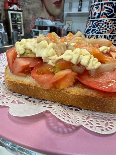 a sandwich with pasta and tomatoes on a pink plate at Hotel Boutique Albussanluis in Muriedas