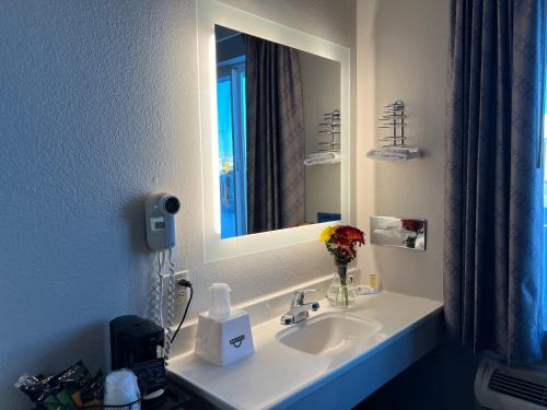 a bathroom with a white sink and a mirror at Days Inn by Wyndham Jamestown in Jamestown