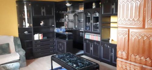 a living room with black cabinets and a couch at Aranyodi hegyi hajlék in Zalaszentgrót