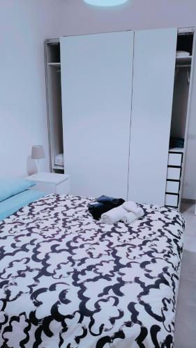 a bedroom with a bed with a black and white blanket at Affittacamere Roberta in Osimo