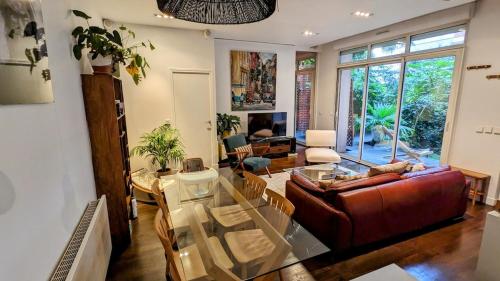 un salon avec une table en verre et un canapé dans l'établissement Beautiful apartment with private garden, à Paris