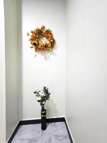 a wreath on a wall with a vase with flowers at Safi House in Boma la Ngombe