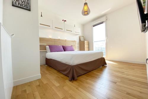 - une chambre avec un grand lit et des oreillers violets dans l'établissement Appartement 3 pièces avec parking 8 people, à Saint-Ouen