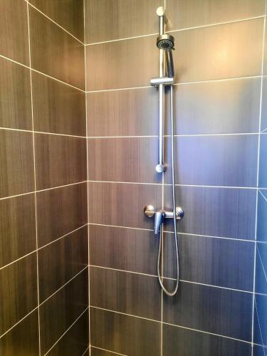 une douche avec pommeau de douche dans une salle de bain dans l'établissement Les Merisiers - Maison moderne avec jardin, à Pornic