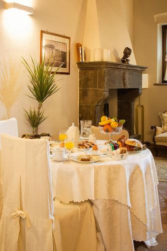 a table with plates of food on it with a fireplace at L'Archetto Dimora Storica in Viterbo