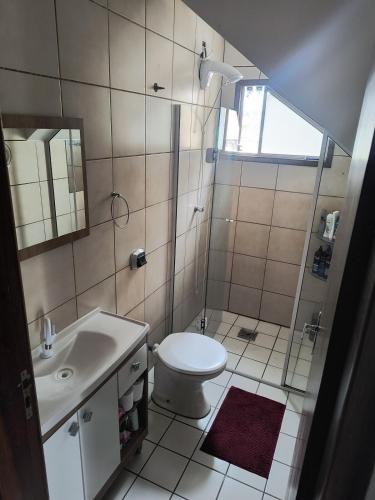 a bathroom with a shower and a toilet and a sink at Pousada Recanto das Palmeiras in Florianópolis