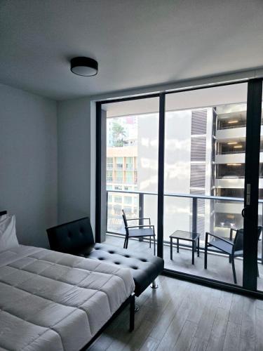 a bedroom with a bed and a large window at Miami Myami Miamí Studio Apartment with Balcony in Miami