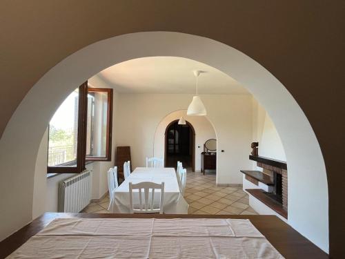 a dining room with a white table and a fireplace at Casa di Farfa in Castelnuovo di Farfa