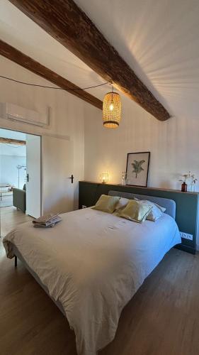 une chambre avec un grand lit et un lustre dans l'établissement Le Granier location, à Robion