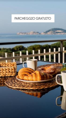 una mesa con un plato de pan y tazas de café en La Vista Formia B&B, en Formia