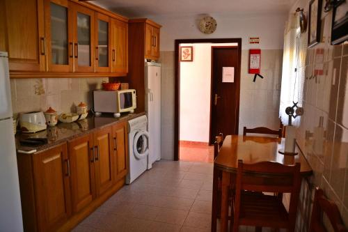 eine Küche mit einem Tisch und einer Mikrowelle in der Unterkunft Monte da Vinha Nova in Santiago do Cacém