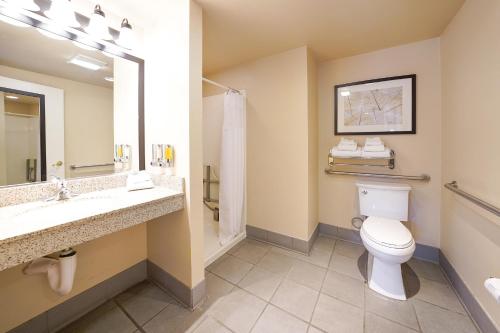 a bathroom with a toilet and a sink and a mirror at San Vicente Golf Resort in Ramona