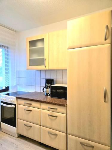 ガルプセンにあるApartments Fuchsbergの木製のキャビネットと白い冷蔵庫を備えたキッチン