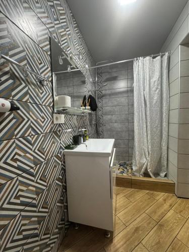 a bathroom with a sink and a patterned wall at Гостинний двір in Yaremche