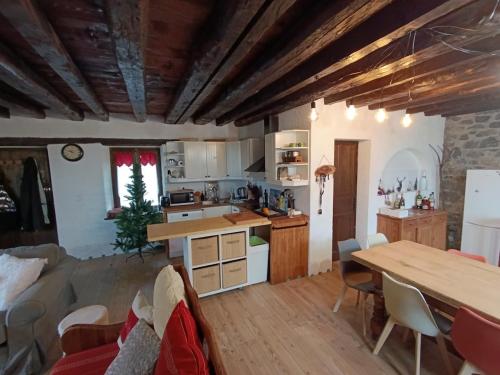 a kitchen and living room with a table and chairs at La fruitière in Verchaix