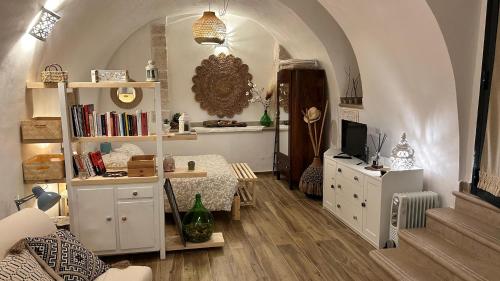 Una sala de estar con una mesa, un sofá y un televisor. en Apollonia suite, en Modugno
