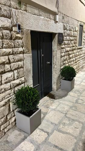 una puerta de un edificio de piedra con dos macetas en Apollonia suite, en Modugno