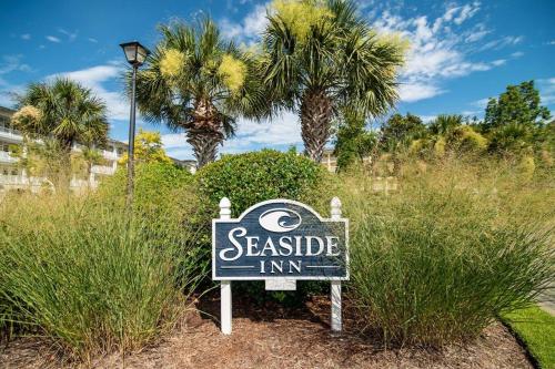 a sign for a seaside inn with palm trees in the background at Sun and Fun 1 Bedroom Resort View Suite Sleeps 4 in Pawleys Island