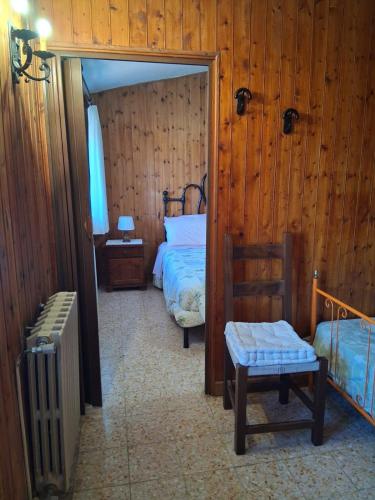 a bedroom with two beds and a chair and a radiator at LA BAITA di Ornaro Alto Rieti - oasi di pace tra Roma e Terminillo in Ornaro