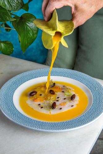a person holding a flower over a plate of food at Fairmont Rio de Janeiro Copacabana in Rio de Janeiro
