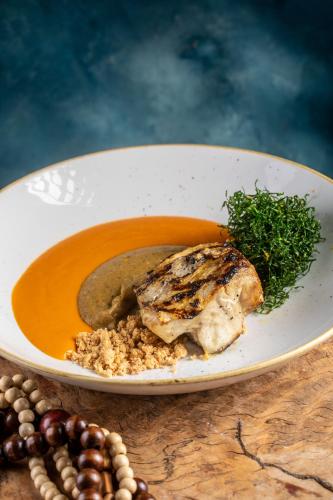 a bowl of soup with a piece of meat and vegetables at Fairmont Rio de Janeiro Copacabana in Rio de Janeiro