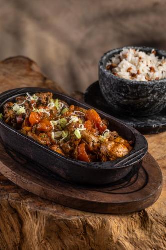 a dish of food on a wooden table with rice at Fairmont Rio de Janeiro Copacabana in Rio de Janeiro