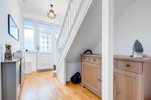 a white staircase with a wooden dresser in a room at Cozy Willow-Hot Tub, Sleeps9, FreeParking, Netflix in Birmingham