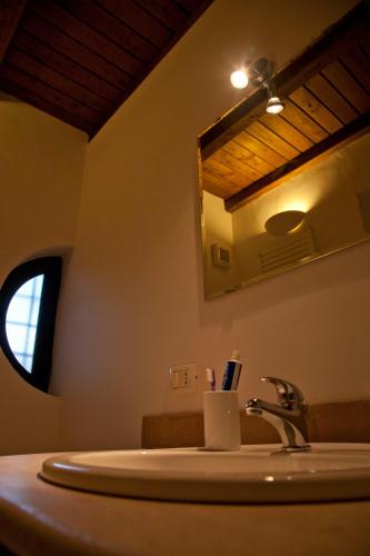 a bathroom with a sink and a mirror at Pietra Pizzuta Country House in Torre deʼ Passeri