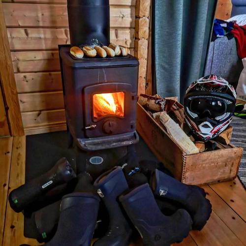 a wood burning stove with a helmet and a helmet at White mountain Lodge in Kalvträsk