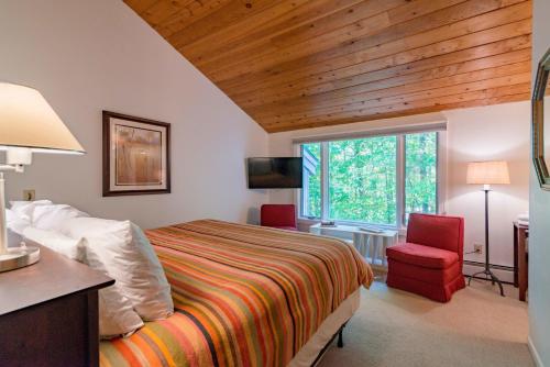 a bedroom with a bed and a desk and a window at Stratton Mountain Ski House Hot Tub Sauna Shuttle in Stratton Mountain