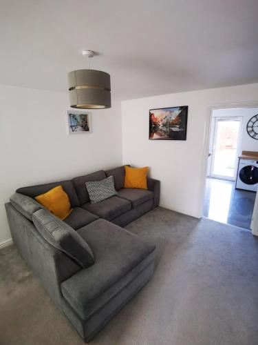 a living room with a brown couch and a window at Spacious 2 BEDROOM HOUSE in Dartford in Dartford