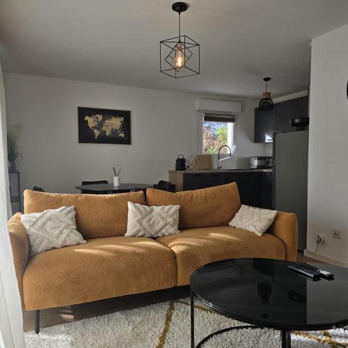 un salon avec un canapé et une table dans l'établissement L'Apaisant, à Thonon-les-Bains