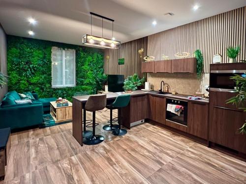 - une cuisine avec une table et un mur vert dans l'établissement BALIROOM Prestige, à Vaulx-en-Velin