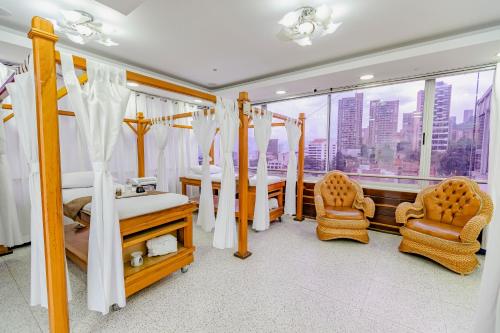 a bedroom with a bed and two chairs and a table at Hotel Du Parc in Medellín