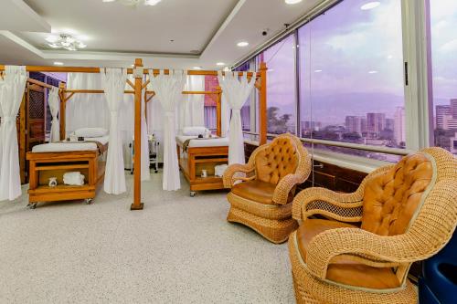 a room with chairs and a bed and a window at Hotel Du Parc in Medellín